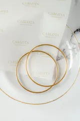 Pulsera rígida de acero quirúrgico con baño de oro 18k.