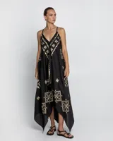 Vestido largo negro con breteles finos y estampado dorado con motivos geométricos. Corte evasé con picos en los laterales.