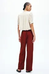 Pantalón de pierna recta en tejido liviano mezcla de lino y viscosa, color rojo. Cuenta con cintura elástica de tiro bajo, cordón de ajuste con cuentas decorativas en los extremos y bolsillos laterales al bies.