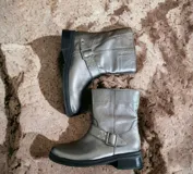 Bota corta de cuero color peltre, con hebilla lateral y suela track.