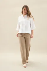 Camisa de lino de calce relajado, color negro, con cuello mao, mangas cortas y bajo redondeado con aberturas laterales.