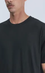 Remera de manga corta y cuello redondo, color negro, confeccionada en algodón premium de tacto suave. Presenta un calce regular con un recorte distintivo en la espalda.