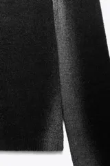 Jersey de punto con cuello redondo amplio y manga larga, presentando un efecto difuminado o degradado en tonos oscuros, posiblemente negro y gris.