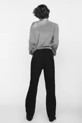 Jeans de tiro alto color negro con efecto lavado, corte mom fit, cinco bolsillos y cierre frontal con cremallera y botón metálico.