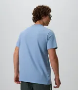 Remera de algodón celeste de corte comfort y holgado, con cuello redondo, manga corta y pequeño estampado circular en el frente.