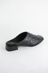 Zueco de cuero color bronce con punta almendrada y detalle de tachas metálicas doradas en toda la capellada. Posee un taco cuadrado bajo de 3 cm.