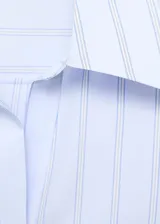 Camisa de corte recto con diseño de rayas verticales en tonos celestes y blancos. Presenta cuello camisero con solapas amplias, cierre frontal de botones ocultos bajo tapeta y mangas largas con puños abotonados.