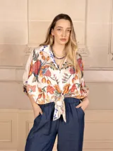 Camisa de seda color crema con estampado floral multicolor, cuello clásico y mangas 3/4 abullonadas.