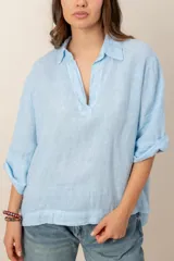 Blusa blanca de lino de manga larga con cuello en V y calce holgado.