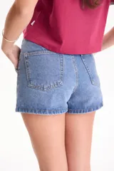 Short pollera de jean negro con spandex, diseño cruzado en el frente y cierre de botones metálicos en la parte superior.