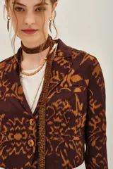 Saco de corte entallado con estampado ikat en tonos marrón y ocre, de manga larga y cierre frontal con botones.