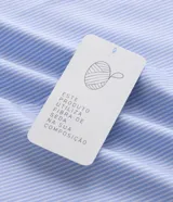 Camisa de corte regular para hombre, en color celeste con finas rayas verticales blancas. Cuenta con cuello camisero tradicional, mangas largas con puños abotonados y cierre frontal con botones.