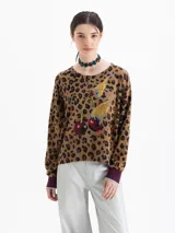 Sweater de punto con diseño animal print, cuello redondo y mangas largas con puños en contraste. Presenta un estampado central de cerezas y detalles bordados.
