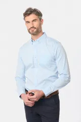 Camisa celeste lisa de corte clásico con cuello abotonado y bolsillo en el pecho.