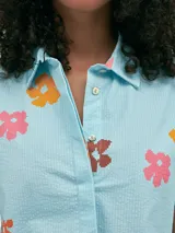 Camisa de manga corta confeccionada en tejido seersucker con estampa de rayas verticales. Presenta cuello camisero, botones anacarados y un diseño de corte recto y fresco.