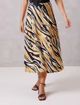 Falda midi de satén con estampado tribal en tonos negro, beige y mostaza. Presenta un corte fluido y cintura elastizada para mayor comodidad.