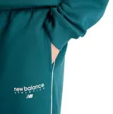 Pantalón deportivo New Balance de corte holgado, confeccionado en felpa cepillada color verde. Presenta cintura elástica con cordón ajustable, bolsillos laterales y logo de la marca estampado en la pierna izquierda.