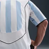Camiseta de fútbol Nike Total 90 con diseño de rayas verticales celestes y blancas. Presenta cuello en V, mangas cortas y el logo circular T90 impreso en el centro del pecho junto con el swoosh de Nike en el lateral superior derecho.