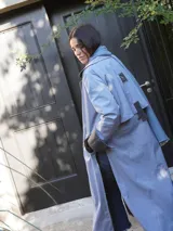 Impermeable color beige con cuello clásico, cierre con botones y cinturón. Detalles en tweed en puños y solapa.