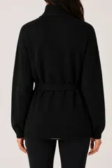 Saco de punto color negro con cuello solapa, manga larga y lazo ajustable en la cintura.