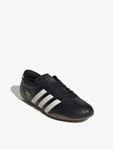 Zapatillas Adidas Tokyo negras con detalles en blanco y suela marrón.