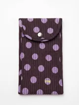 Estuche para lentes de sol de tela acanalada color marrón con estampado de lunares lilas, cierre de solapa con botón a presión metálico y detalle bordado con las siglas SYM.