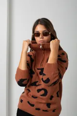 Buzo de tejido de punto con estampado animal print, cuello alto con cierre frontal y mangas largas.