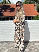 Vestido largo de lanilla color fucsia con estampado animal print negro, de corte recto y mangas largas.