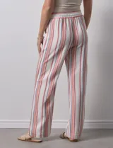 Pantalón de lino de la marca Marissa Olivia, con pretina ancha elastizada y lazo de ajuste. Diseño a rayas verticales en blanco, rojo y azul. Cuenta con bolsillos inclinados en la parte delantera.