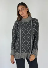 Sweater de lana color bordó con cuello alto y diseño de rombos y líneas verticales en rojo. Tiene puños y dobladillo acanalados.