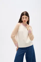 Sweater de punto con diseño color block, presenta cuerpo en color rosado, mangas en azul marino y detalles de cuello y puños en color verde oliva. Posee un corte holgado y cuello redondo a la base.