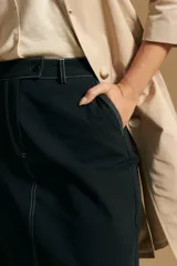 Falda midi negra de denim con costuras blancas contrastantes y tajo frontal.