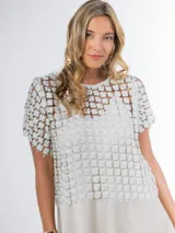 Blusa italiana calada con diseño floral en tono champagne, de mangas cortas y calce oversized.