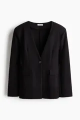 Blazer de punto grueso en color negro con hombreras, escote en V sin cuello, cierre de un botón y bolsillos frontales con solapa.