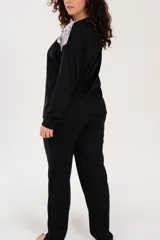 Pijama negro de algodón con detalle de puntilla bicolor en el escote. El pantalón es de tiro alto y corte recto.