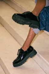 Zapatos tipo wallabee de cuero metalizado en tono peltre, con cordones negros y suela track de goma negra con plataforma.