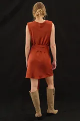 Vestido corto sin mangas de satén color marrón, con cuello buche, hombros caídos y un lazo ajustable en la cintura.