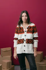 Saco tejido a mano con diseño jacquard, de corte recto y largo a la cadera. Presenta cuello redondo, cierre frontal con botones y mangas largas. Incluye tajos laterales en el ruedo.