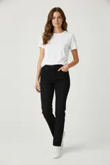 Pantalón de jean negro, corte skinny, tiro medio, con cinco bolsillos y cierre de botón y cremallera.