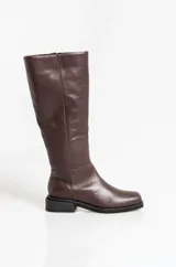 Botas de caña media confeccionadas en cuero vacuno, con diseño de punta redondeada y suela plana con pequeño taco cuadrado. Presentan costuras verticales decorativas a lo largo de la caña.
