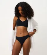 Bombacha de bikini hilo tipo vedetina, color negro, confeccionada en poliamida seamless con acabado texturizado de canalé y cintura ancha.