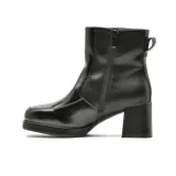 Bota de vestir de caña media en color marrón, con taco cuadrado y plataforma delantera. Presenta un diseño minimalista con costuras visibles y detalle de borde en color negro.