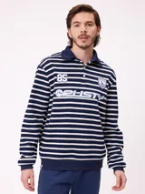 Polo de manga larga con diseño a rayas horizontales en azul marino y blanco. Presenta cuello tipo polo con cierre de botones, estampado frontal con el logo de la marca y el número 85, y puños elásticos.