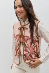 Camisa de algodón con estampado de rayas verticales en color bordó y blanco. Presenta un diseño de manga larga con puños abotonados, cuello camisero y un detalle de volado lateral que recorre el frente desde el cuello hasta el ruedo, acompañando la línea de botones.