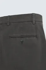 Bermuda de hombre color beige claro, corte regular fit, con pliegues frontales, bolsillos delanteros y bolsillos traseros de doble vivo con botón.