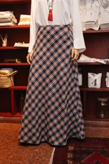 Pollera larga de corte evasé con estampado de cuadros escoceses en tonos azul, rojo y blanco.