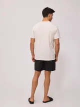 Remera color crema de manga corta con cuello redondo y bolsillo en el pecho con logo estampado de Rusty Shop Surf Services.