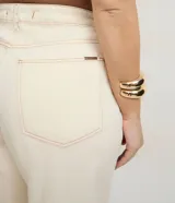 Pantalón femenino curve & plus size color beige, confeccionado en sarga de algodón certificado. Presenta un modelo recto, cierre delantero con botón y cremallera, bolsillos delanteros y traseros funcionales, y bajo con acabado deshilachado.