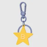 Charm para bolso con forma de estrella amarilla y letra B en relieve, unido a un mosquetón y argolla de color azul lavanda.