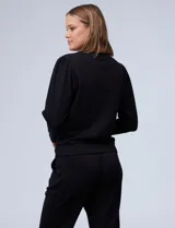 Buzo gris claro de jersey, marca Nanette, con cuello redondo y mangas largas abullonadas con detalle de pinzas en los hombros.